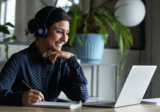 woman learning at laptop with headphones on