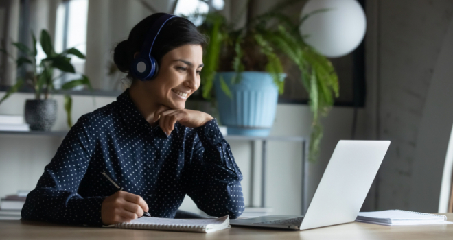 woman learning at laptop with headphones on