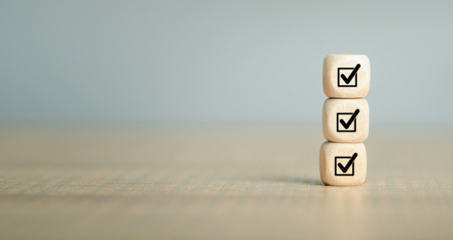 three wooden blocks stacked with printed ticks on